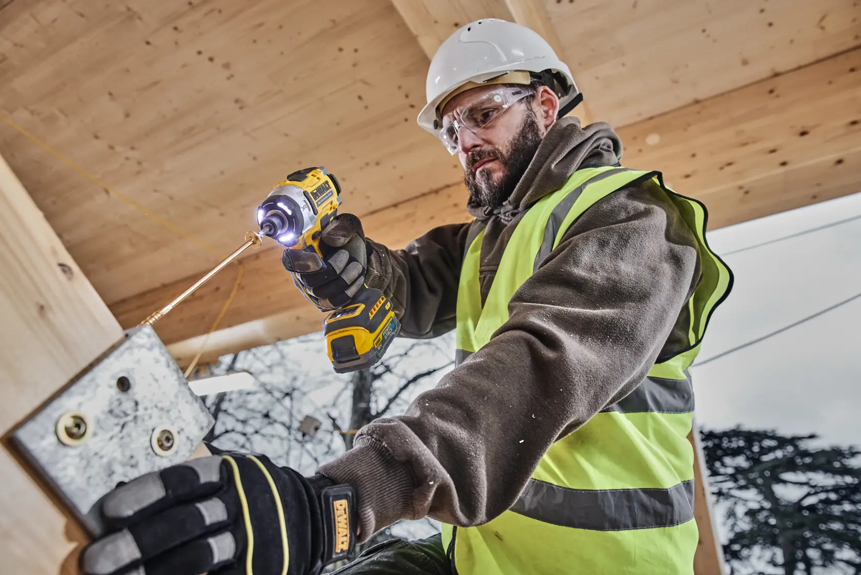 Trabajador usa taladro DEWALT DCK2201P1T1-XE, DCF860NT en obra. Categoría fotografía.