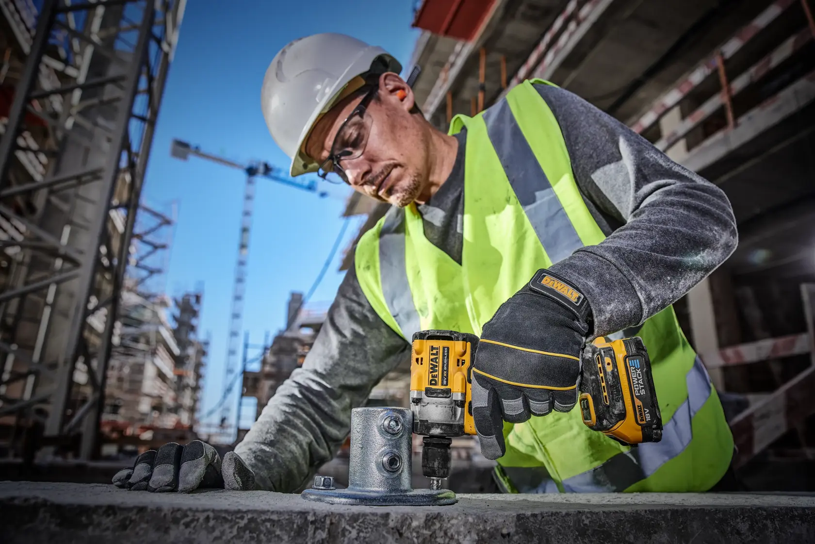 Primo piano della batteria compatta al litio DEWALT POWERSTACK 18V XR su uno sfondo blu futuristico. Il testo sottostante evidenzia che DEWALT è il primo marchio di elettroutensili ad utilizzare celle a sacchetto progettate per l’edilizia.