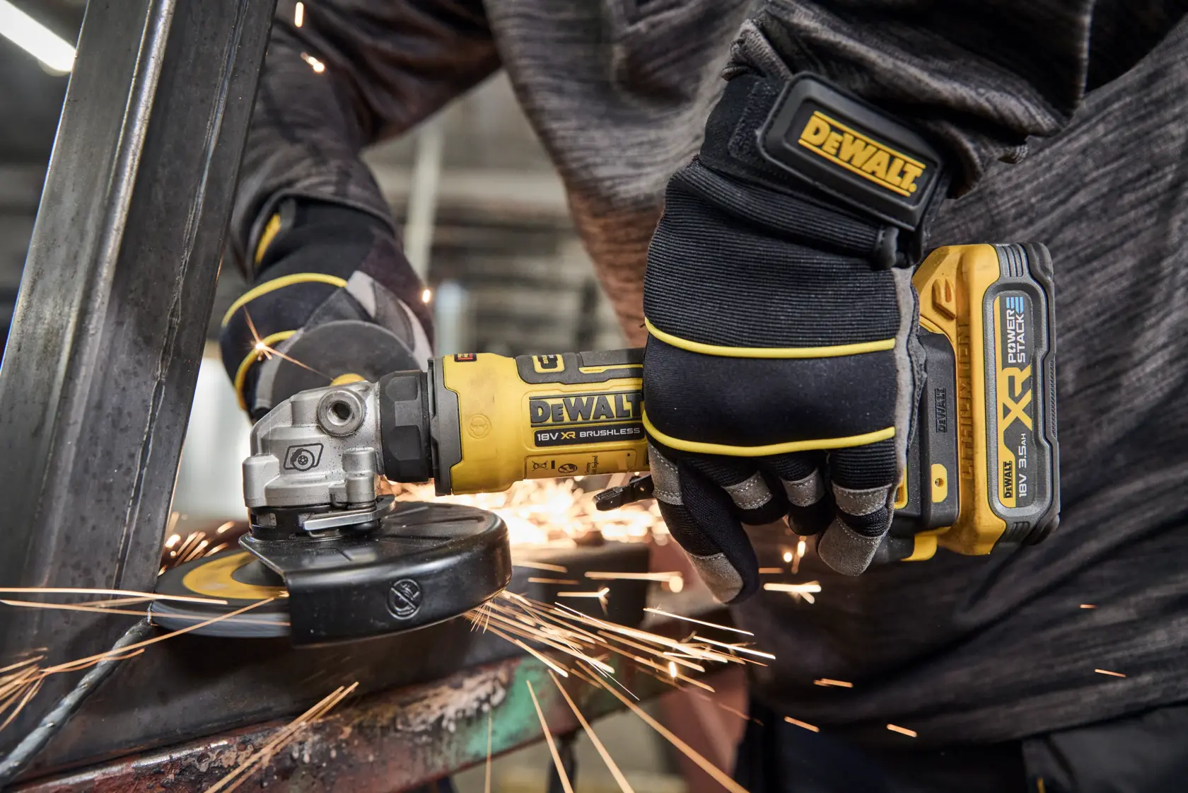 Person using a DEWALT cordless angle grinder on metal, sparks flying during operation.