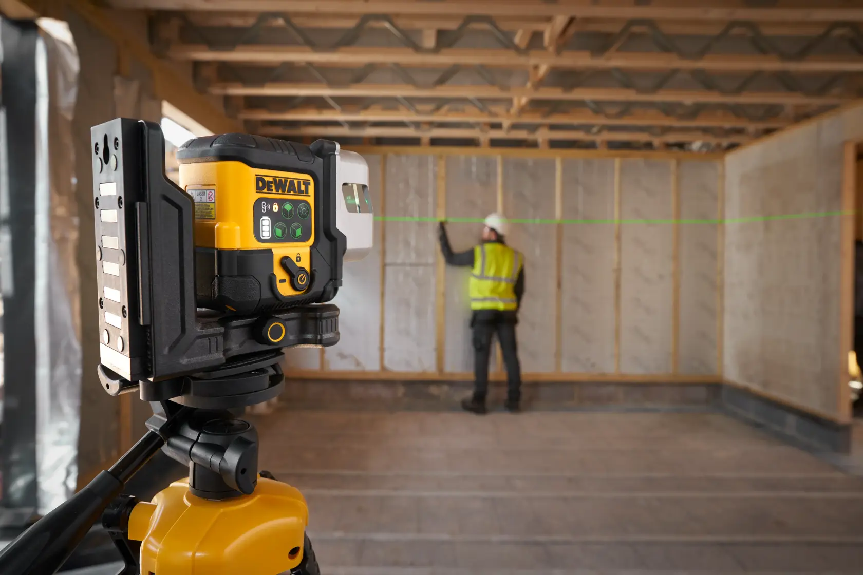 Arbeiter verwendet DEWALT grünen Laser zur Ausrichtung in einem Rohbau.