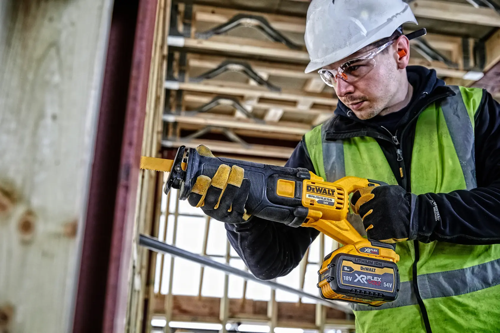 Persona usando una sierra DEWALT DCS389NT en una obra, con guantes y equipo de seguridad.