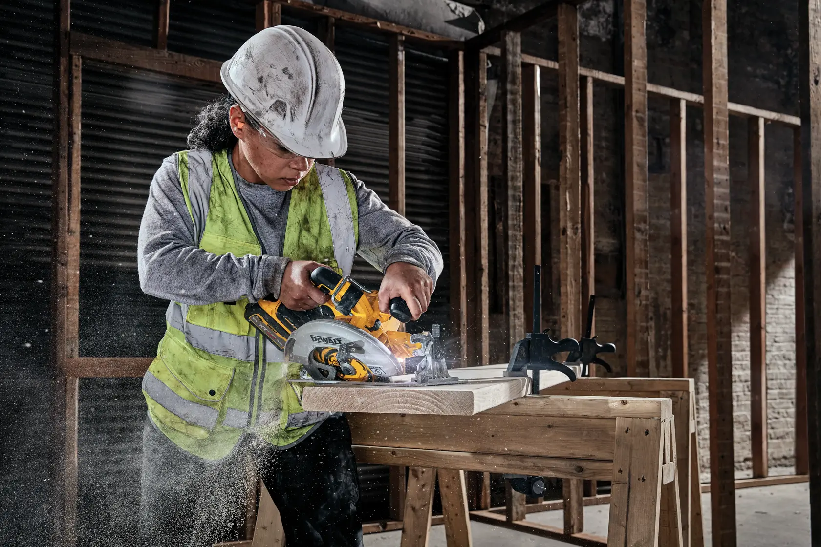 Operaio taglia legno con sega circolare DEWALT DCS573NT in cantiere.