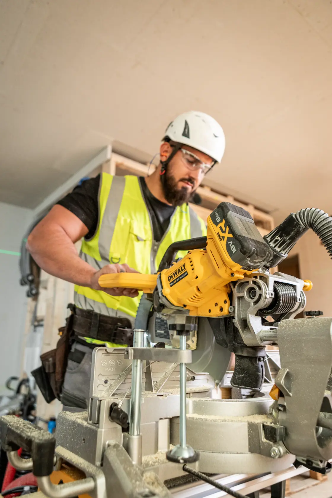 Trabajador usa la sierra amarilla DEWALT DCS782N en obra, con chaleco reflectante y casco.