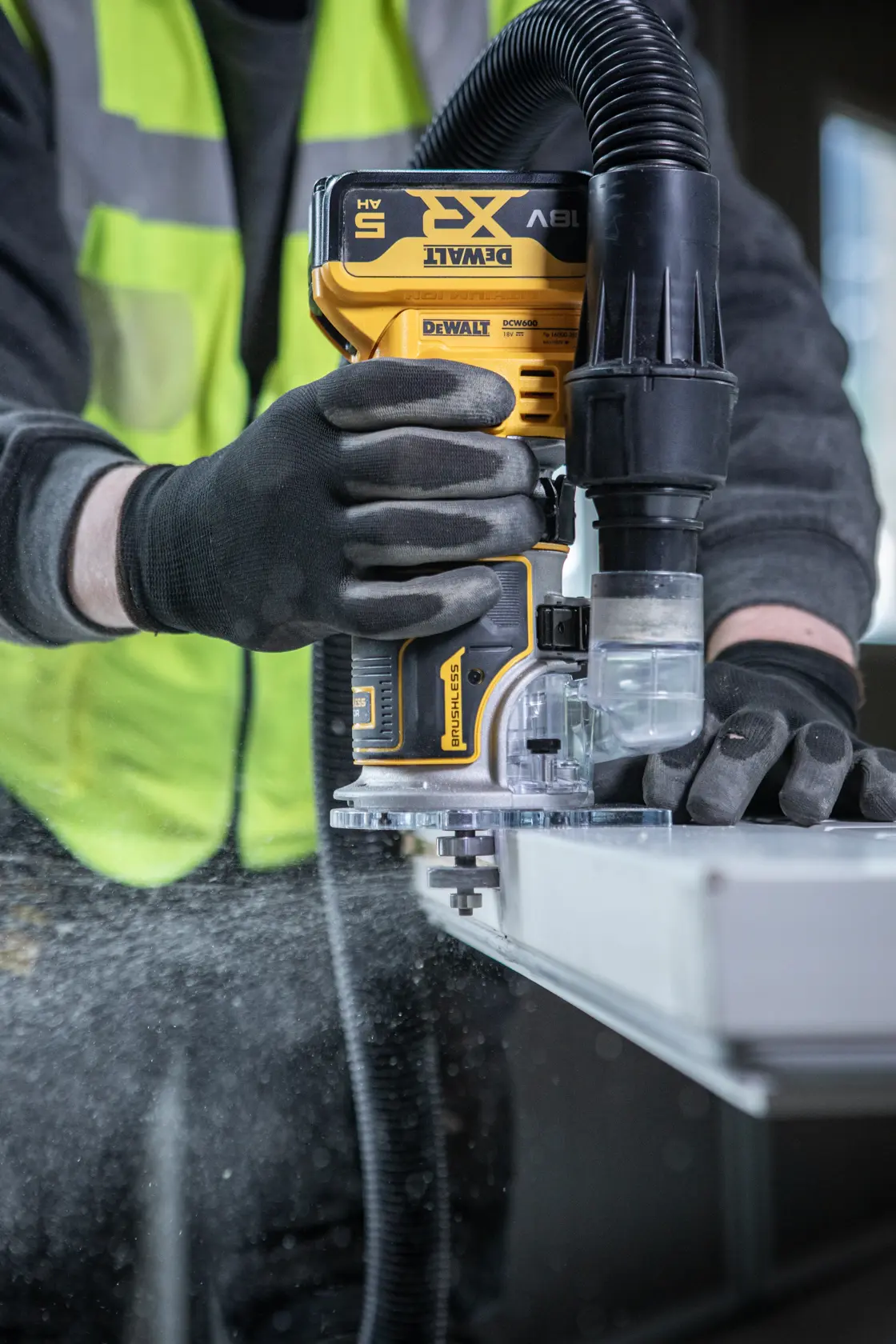 DEWALT DCW604NT-XJ, DCW604NT défonceuse utilisée avec extraction de poussière. Catégorie photographie.