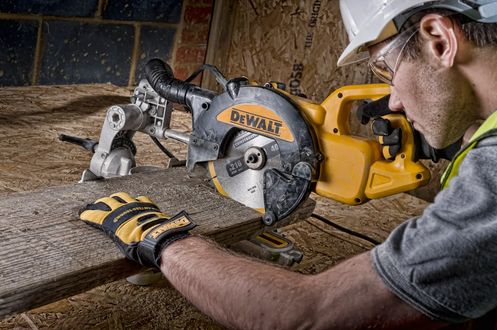 DEWALT Kappsäge schneidet Holz, bedient von Person mit Handschuhen und Helm auf Baustelle.